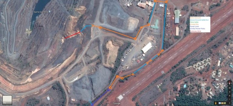 Satellite view of a mining site with paths marked in different colors, showing a detailed route layout.